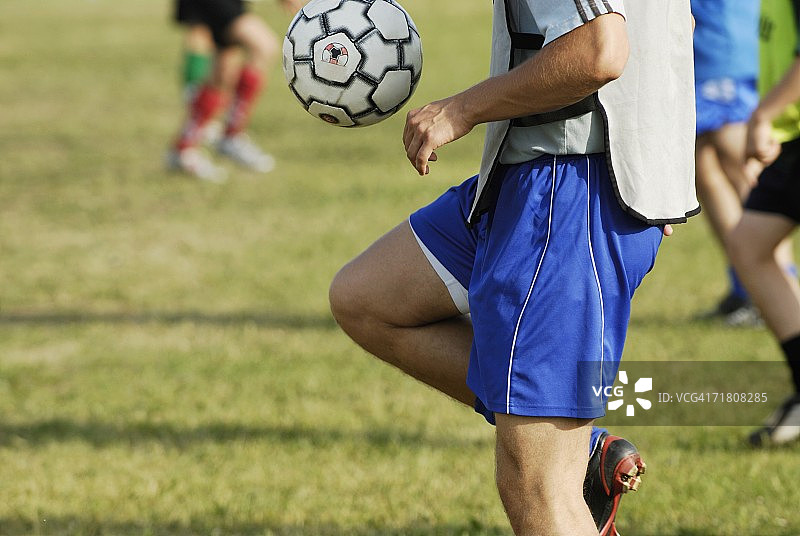足球运动员用大腿平衡足球的半身照图片素材