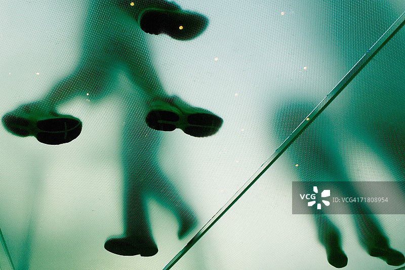 仰视视角下的玻璃地面四人图片素材