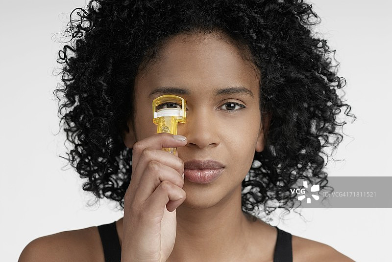 年轻女人使用睫毛夹特写图片素材