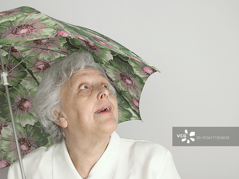 拿着雨伞的年长妇女图片素材