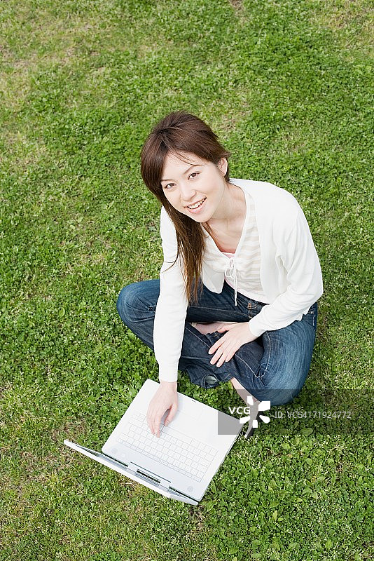 女人在户外使用笔记本电脑图片素材