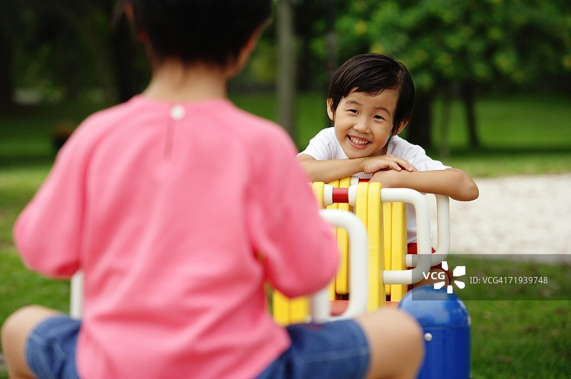 在跷跷板上玩耍的两个女孩图片素材