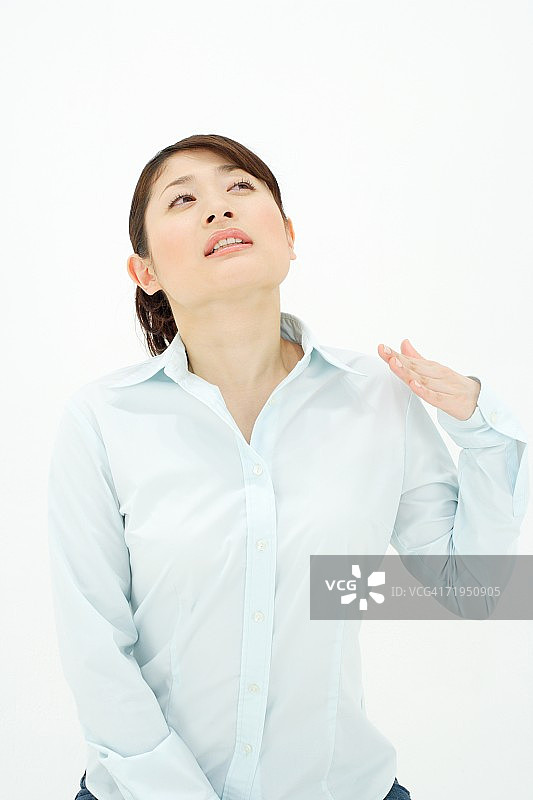 用手给自己扇风的年轻女人图片素材