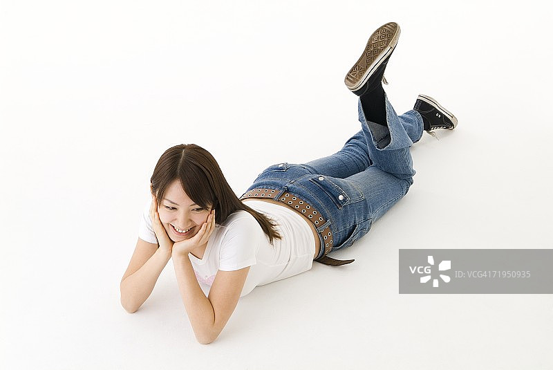 年轻女人面朝下躺着微笑图片素材