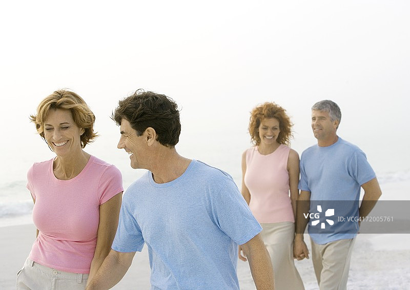 两对中年夫妇在沙滩上散步图片素材