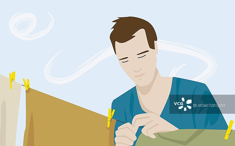 把衣服晾在晾衣绳上的年轻男子特写图片素材