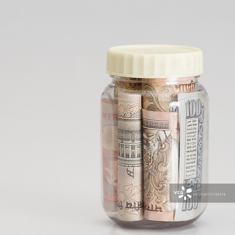 罐子里不同面额的印度钞票卷特写图片素材