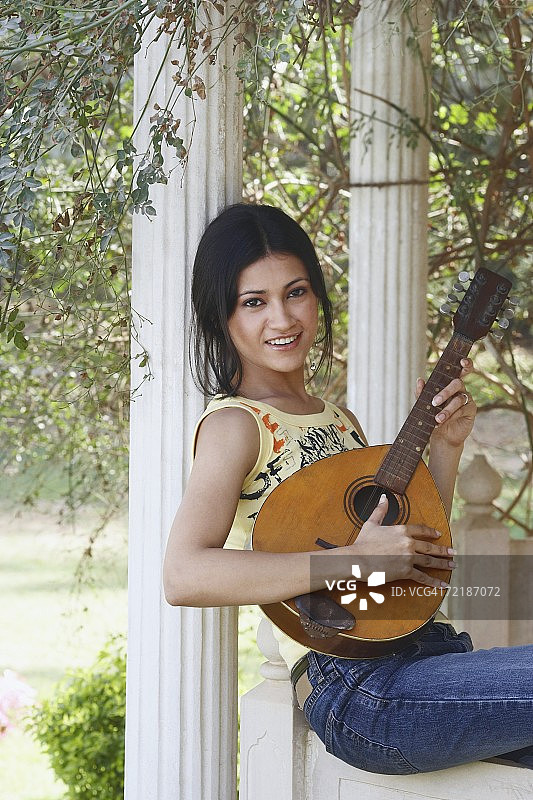 手持曼陀林的年轻女性肖像图片素材