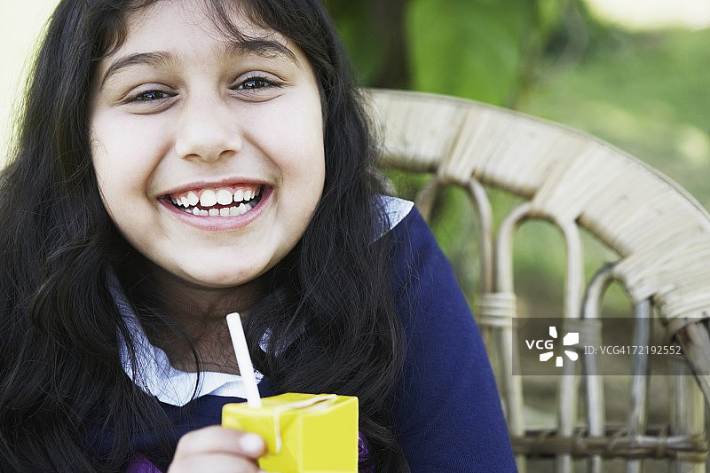 女孩拿着果汁盒的肖像图片素材