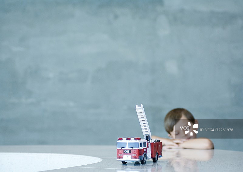 男孩在玩具消防车后做梦图片素材
