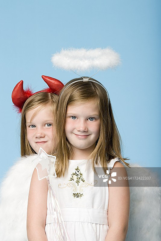 打扮成天使和恶魔的双胞胎女孩图片素材