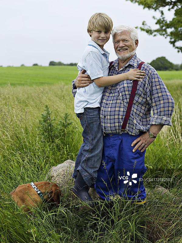 祖孙（7-8岁）与狗在田野合影图片素材
