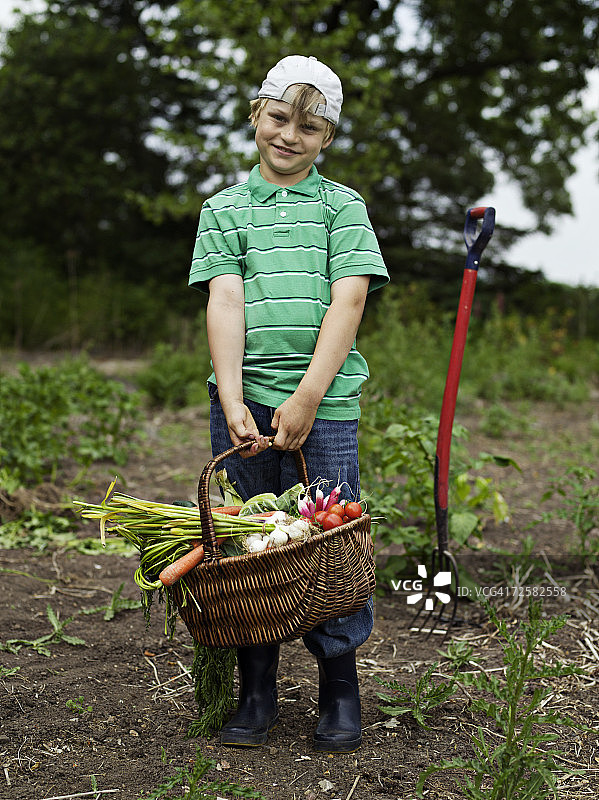 小男孩（8-9岁）拿着一篮蔬菜图片素材