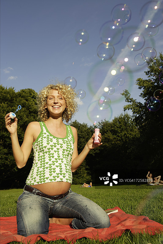 孕妇吹泡泡，面带微笑图片素材
