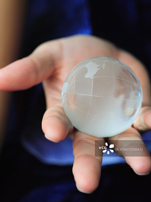 手持地球仪的人的手部特写图片素材