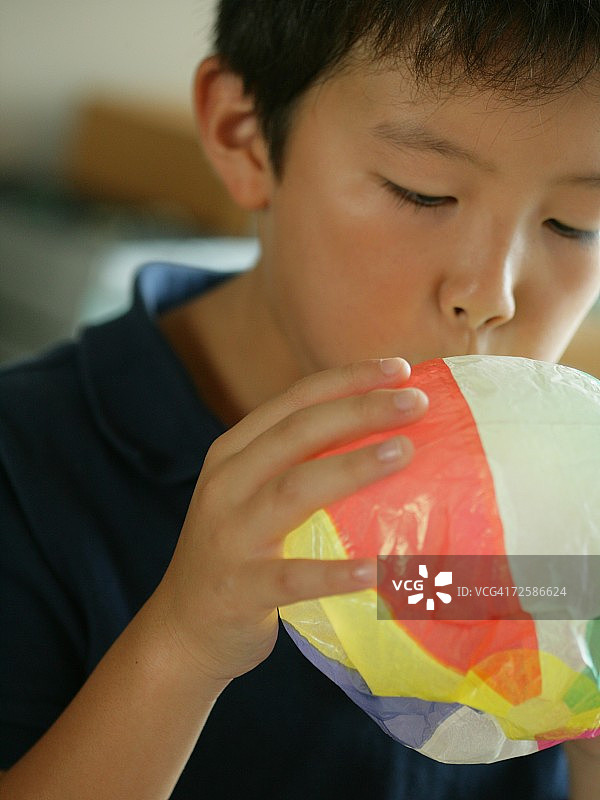 吹纸气球的男孩特写图片素材