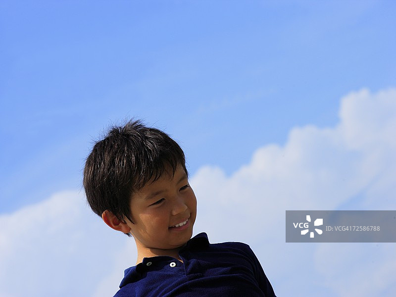 仰视角度拍摄的微笑男孩图片素材
