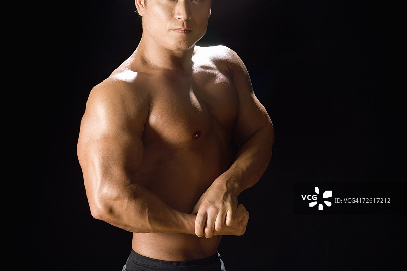 黑色背景下展示肌肉的健壮男人（正面）图片素材