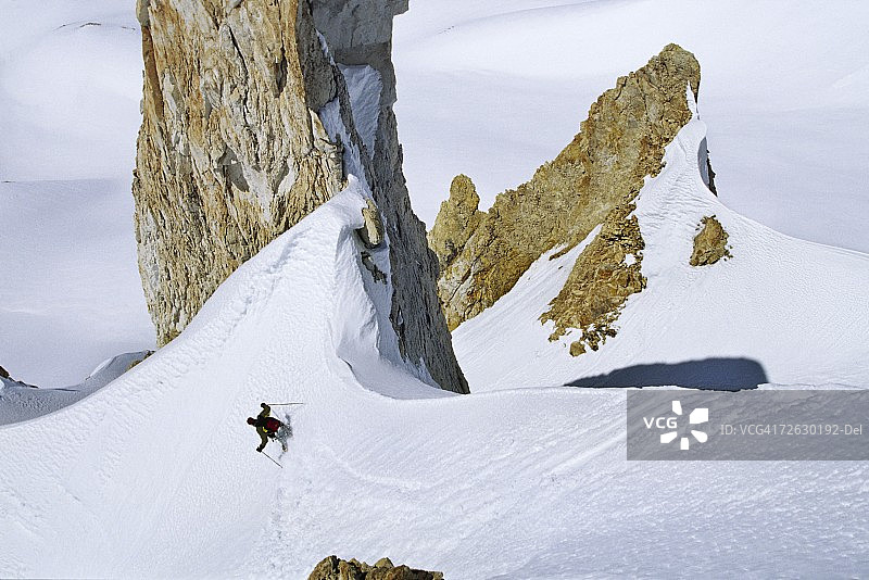 在阿根廷岩石尖顶下滑雪的人图片素材