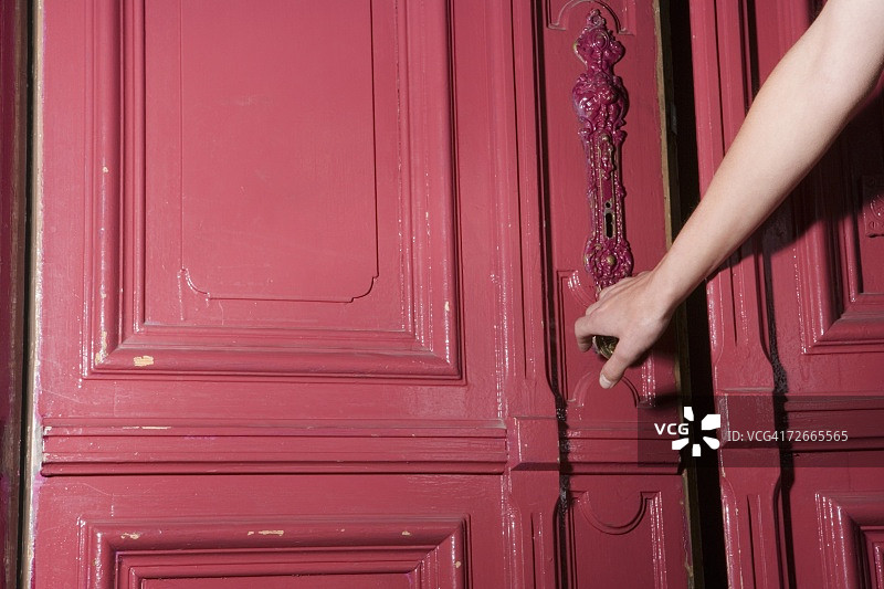 女人关上公寓的粉色门图片素材