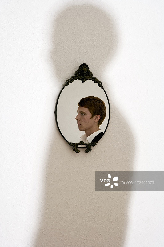 华丽镜子中年轻男子的倒影图片素材