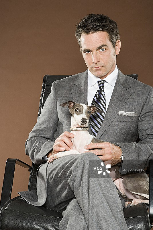 男人坐在椅子上抱着狗图片素材