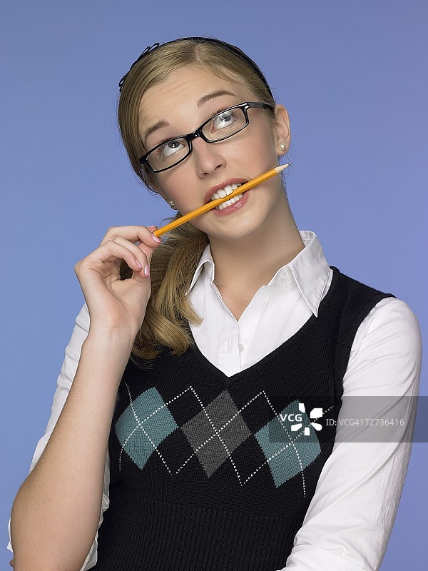若有所思的女孩咬着铅笔图片素材