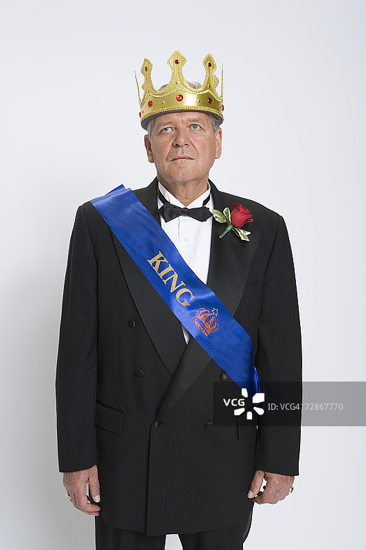 戴着国王王冠和绶带向上看的中年男人图片素材