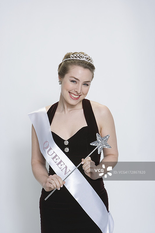 戴着皇冠和绶带、手持魔杖的选美皇后图片素材