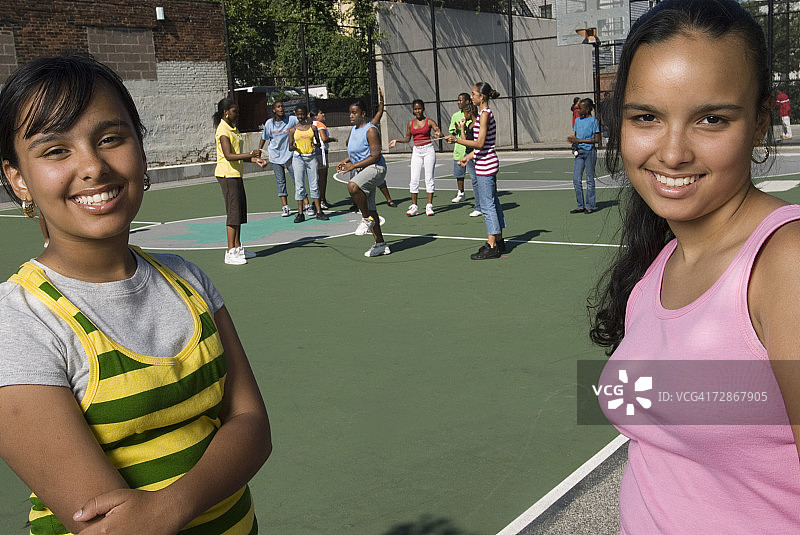 微笑的少女（14-15岁），一群女孩在背景中跳绳图片素材