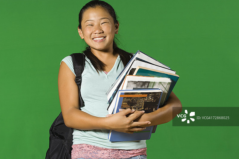 抱着一堆书微笑的少女图片素材