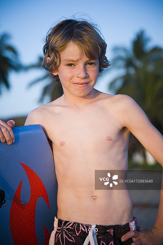 在海滩上玩趴板的男孩图片素材