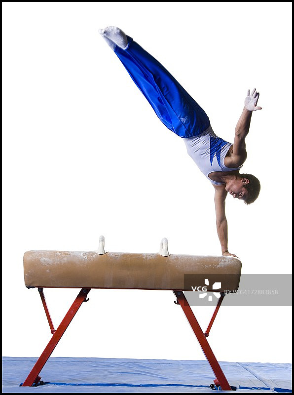 男子体操运动员在跳马上进行例行表演图片素材