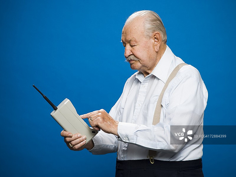 用老式无线电话打电话的老年男人图片素材