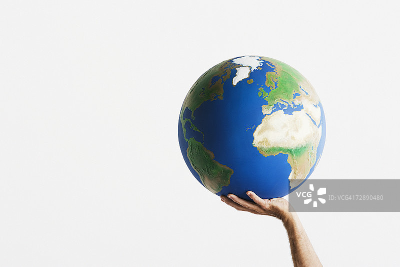 女人举起双手捧着地球仪，白色背景，特写图片素材
