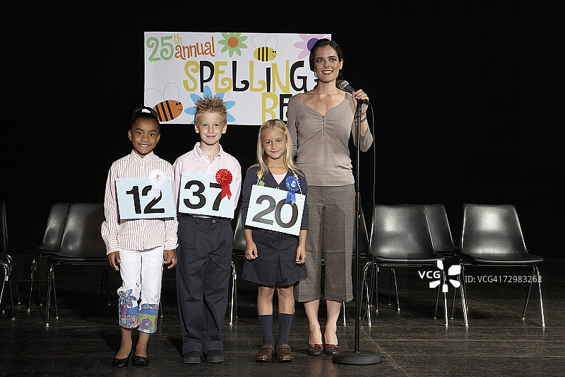 拼写比赛活动中与老师在一起的三个孩子（7-9岁）图片素材