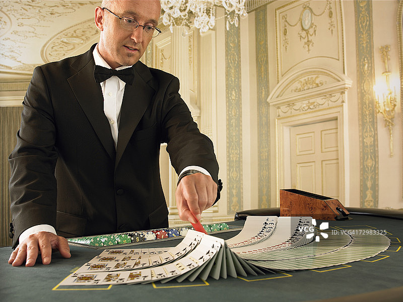 赌场内，男人在21点牌桌上准备纸牌图片素材