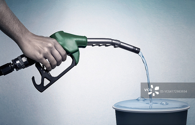 男人将汽油抽入桶中，手部特写图片素材
