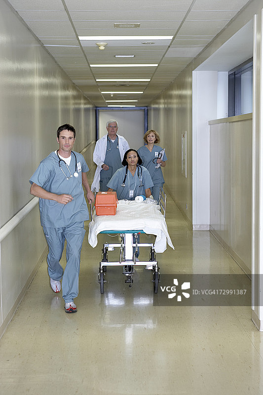 医生推着医院手推车在走廊里奔跑图片素材