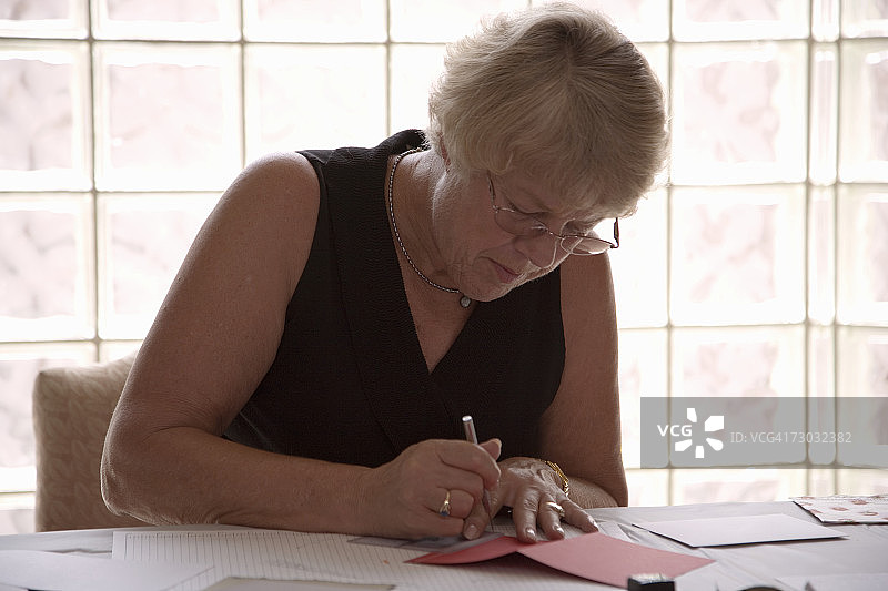 年长的女人在家里制作贺卡图片素材