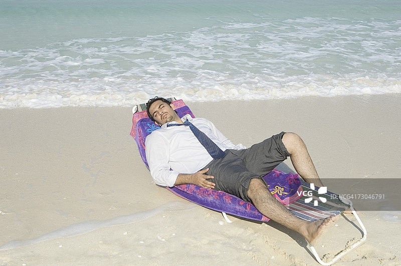 穿着正装在海滩上放松的商人图片素材