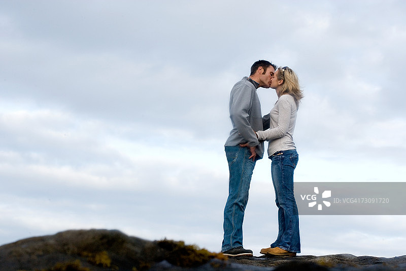 在悬崖顶上亲吻的情侣图片素材