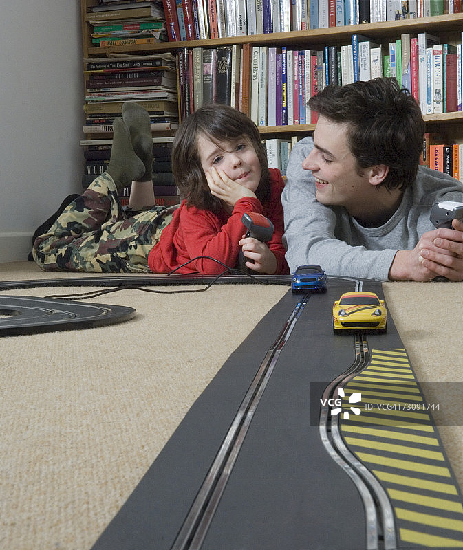 和男人一起赛玩具车的男孩（5-7岁）图片素材