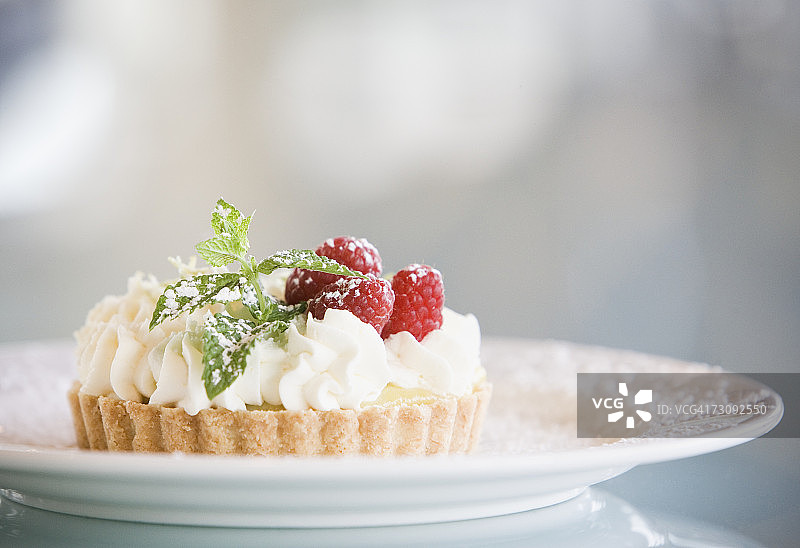 盘子里的覆盆子奶油糕点特写图片素材