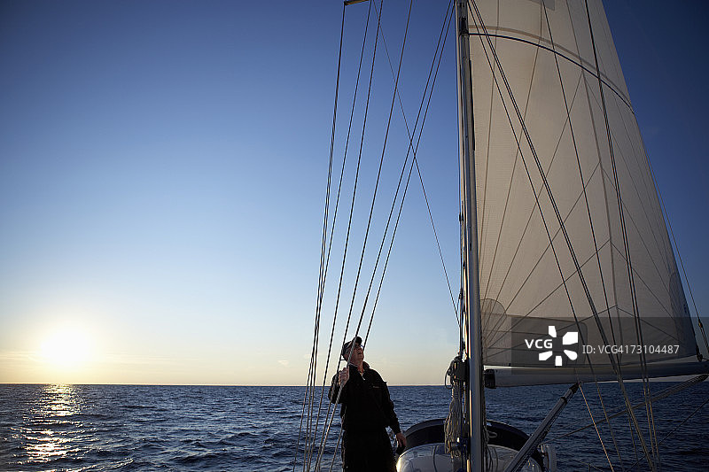 仰望帆船上风帆的男人轮廓图片素材