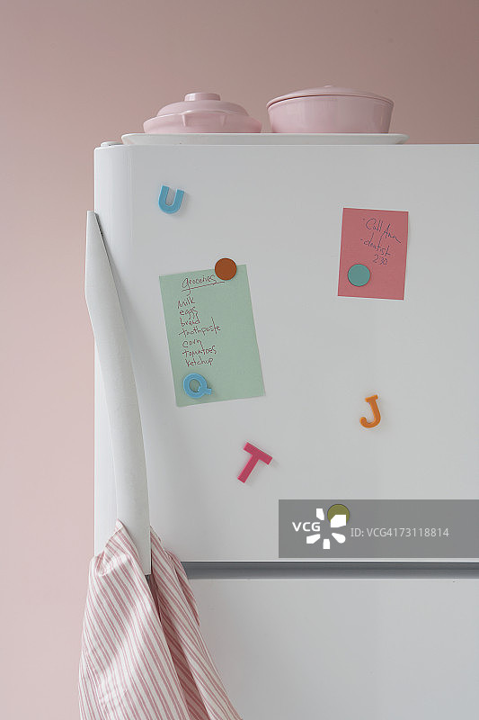 贴有便签和磁铁的冰箱特写图片素材