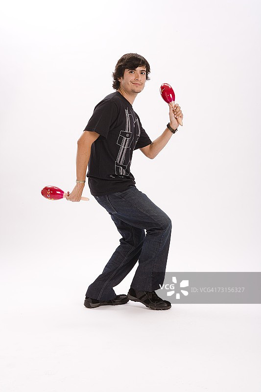 年轻男子跳舞并摇动沙槌的影棚人像图片素材