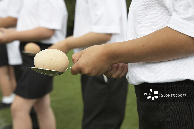 孩子们用勺子平衡鸡蛋图片素材