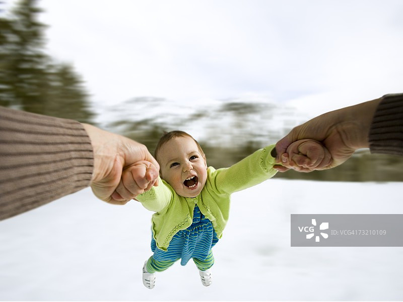 冬天里母亲在户外荡着孩子图片素材