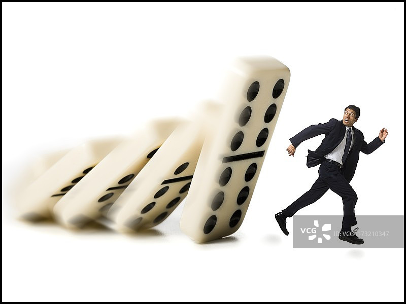 商人逃离倒下的多米诺骨牌图片素材